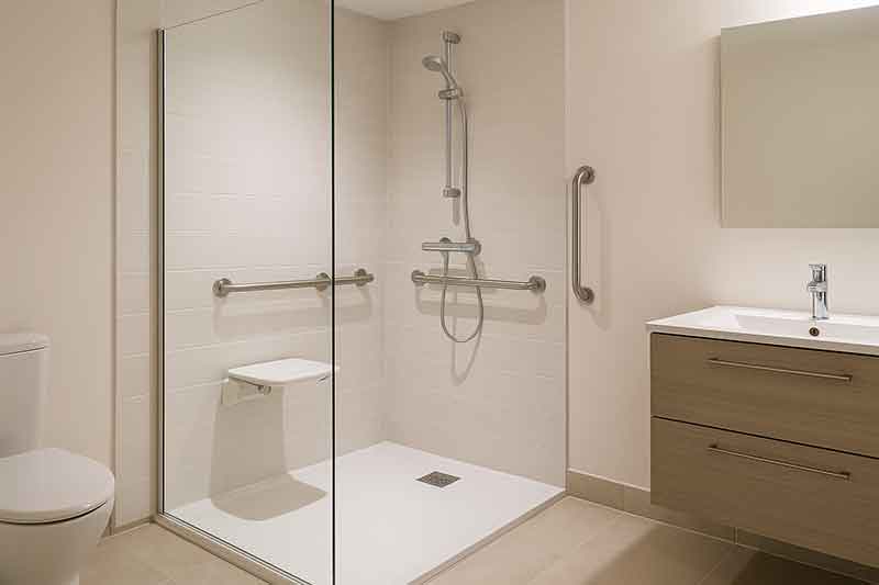 Douche senior sécurisée avec siège et barres d'appui